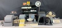 Full view of vintage office lot including Dominion Electrohome fan, Rolodexes, hole punchers, staplers, paper trays, lamp, and other tools.
