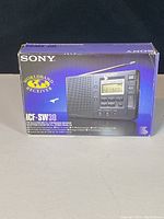 Box of Sony ICF-SW30 World Band Receiver showing front with product photo and features.