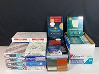 Photo showing various unopened boxes of letter paper, envelopes, and color paper from multiple brands stacked together