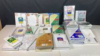 Full overview of the entire assortment laid out on a table, showing multiple packets of stationery papers and envelopes stacked and spread out.