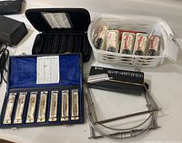 Overview of harmonicas including C.A. Seydel Söhne set in blue case, multiple boxed Marine Band harmonicas, Swan harmonica box and harmonica holders.