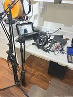 Microphone stands and microphones on a white table with wood floor background