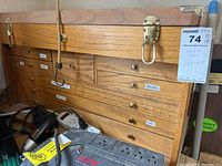 Wooden tool chest with multiple labeled drawers and brass latches