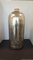 Front view of tall metallic-finished glass vase showing cylindrical form and distressed texture