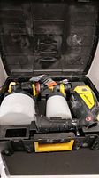 Two Wagner paint sprayers with attached paint containers in a hard plastic black case with yellow handle.