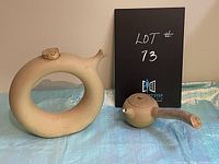 Front view of the clay wine decanter and clay teapot showing shape, cork lid, and wooden handle.