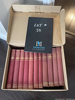 Box with nine volumes of The Second Great War military history books, red cloth hardcover with gold embossed titles, volumes 1-4 and 6-9 present, volume 5 missing.