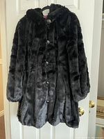 Front view of the black plush women's jacket showing hood, buttons, and texture