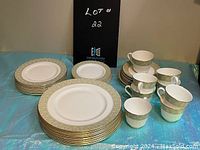 Overview photo showing full set of Royal Doulton dishes, Sonnet pattern, with various sized plates, teacups, and creamers arranged on a table.