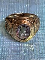 Front view of 10K gold signet ring showing central gemstone and floral engraving