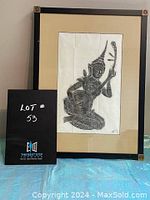 Front view of the framed Thai rubbing artwork showing the entire piece with framed beige mat and black frame with corner accents.