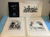 Portfolio of three loose leaf French cartoons displayed side by side on a blue cloth background, showing the detailed ink drawings and captions in French.
