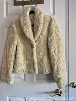 Front view of white plush Kenzie jacket hung on hanger showing texture and single button closure.