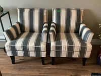 Front view of the pair of accent chairs showing striped upholstery and dark wood legs