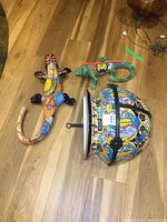 Photo shows the clay planter, two painted iguanas on wooden floor, illustrating size and colorful patterns.