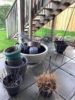 Photo showing stacked planters in various sizes and colors, chicken wire, resin pond, and wire trellises.