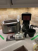 Photo showing the Sears Pro toaster, Bunn coffee maker with carafe, Cuisinart kitchen scale and accompanying manual on a kitchen counter.