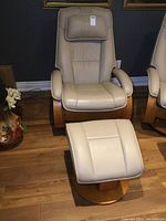 Front view of leather recliner and matching ottoman on wood floor