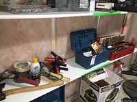 Wide shot of two toolboxes: metal red toolbox and blue plastic toolbox with various hand tools and accessories arrayed on shelf