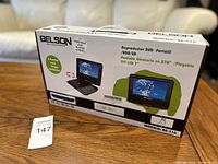 Boxed Belson 7 inch Portable DVD Player model BS-116, original packaging shown on wooden table.