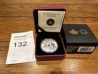 Front view of the 2014 $20 fine silver coin titled 'Pond Hockey' inside burgundy velvet presentation case, with outer black box and MaxSold lot tag 132 visible.