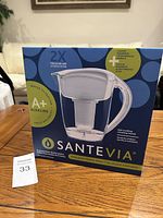 Box of Santevia alkaline water pitcher with branding and product details visible.