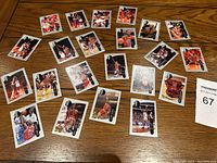 Photo showing a complete spread of 23 Michael Jordan Upper Deck basketball cards on a wooden floor.