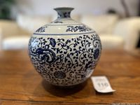 Front view of the vintage blue and white porcelain vase showing detailed dragon and floral vine design and rounded shape with lid.