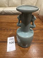 Front view of vintage Chinese porcelain vase with double ears and flared rim on wooden floor, showing shape and glazing