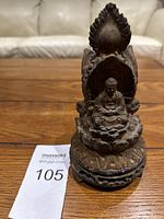 Front view of the vintage metal Buddha statue showing seated Buddha on lotus base with ornate backing.