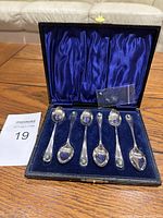 Open presentation box showing 6 vintage sterling silver spoons with turquoise stones on handles set in blue velvet lining.