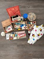 Full view of assorted sewing notions including threads, needles, buttons, pins, and a piece of birthday fabric