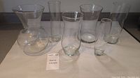 Photo showing all six glass vases on a countertop, ranging from short wide vase to taller slender vases.