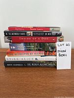 Stack of seven books showing spines including dog books and novels with a note 'LOT 60 mixed books'.