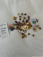 Mixed group of lapel pins showing various small metal pins with enamel details including a Victoria 94 pin, animal shapes, and club insignias.