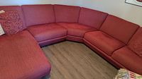 Full view of the L-shaped red sectional sofa showing fabric upholstery and overall size