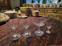 Four Baccarat crystal glasses: tall white wine, shorter red wine, coupe parfait and small cordial