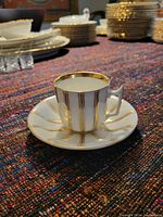 Espresso cup on matching saucer showing gold striped decor and elegant shape