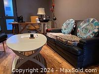 Ikea drop-leaf coffee table shown in a living room setting with two pastel patterned round back cushions on a couch. The table is light green and positioned in front of the couch.