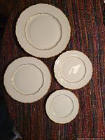 Four plates of different diameters displayed flat on fabric background
