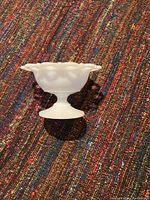 Side profile view of milk glass candy dish showing hobnail texture and pedestal base.