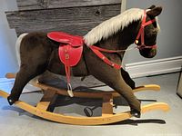 Full side profile of the brown plush rocking horse on wooden rockers