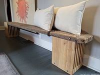 Front profile view of rustic wooden bench showing slatted seat, metal strap details and block style leg