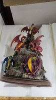 Front view of composite dragon figurine showing multiple colored dragons perched on a rocky castle base.