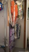 Photo of linen tea towels in colors orange, purple, and floral patterns, all sealed in plastic bags.