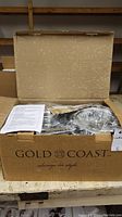 Box containing Gold Coast cookware set and packaging.