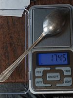 Photo of the sterling silver spoon placed on a digital scale showing weight of 17.45 grams