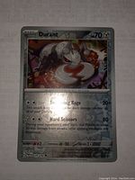Clear image of the Durant Pokémon card showing holo foil effect and text detailing the card's features and attacks.