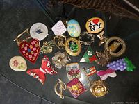 Photo of a collection of various vintage handmade costume brooches in different shapes, colors and materials.
