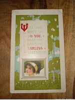 Front of early 1900s Valentine's Day postcard with colorful printed message, decorative illustration, and an image of a young woman's face.